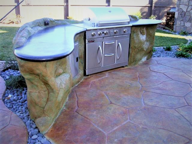 custom outdoor BBQ kitchen with polished concrete counter top and stamped concrete patio